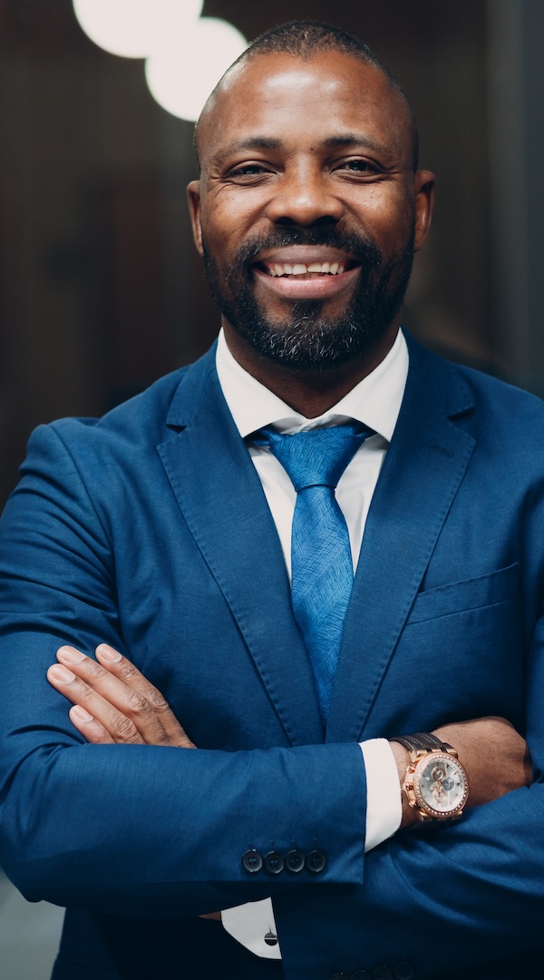 Portrait smiling african american businessman in blue suit in office The Revolution Will Be Digital, African American Economics, Black Economics, African American Housing, Black Housing, African American Wealth, Black Wealth, African American Education, Black Education, Historical Black Colleges and Universities, HBCU, African American Health, Black Health, African American Health Care, Black Health Care, African American Jobs, Black Jobs, Misinformation, Disinformation, KOLUMN Magazine, KOLUMN, African American Politics, Black Politics, African American Vote, Black Vote, African American Home Ownership, Black Home Ownership, Diversity, Equity, Inclusion, DEI